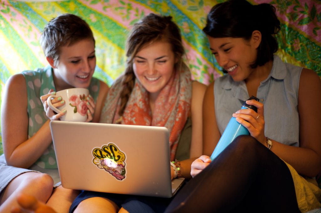 Three students browsing on a laptop